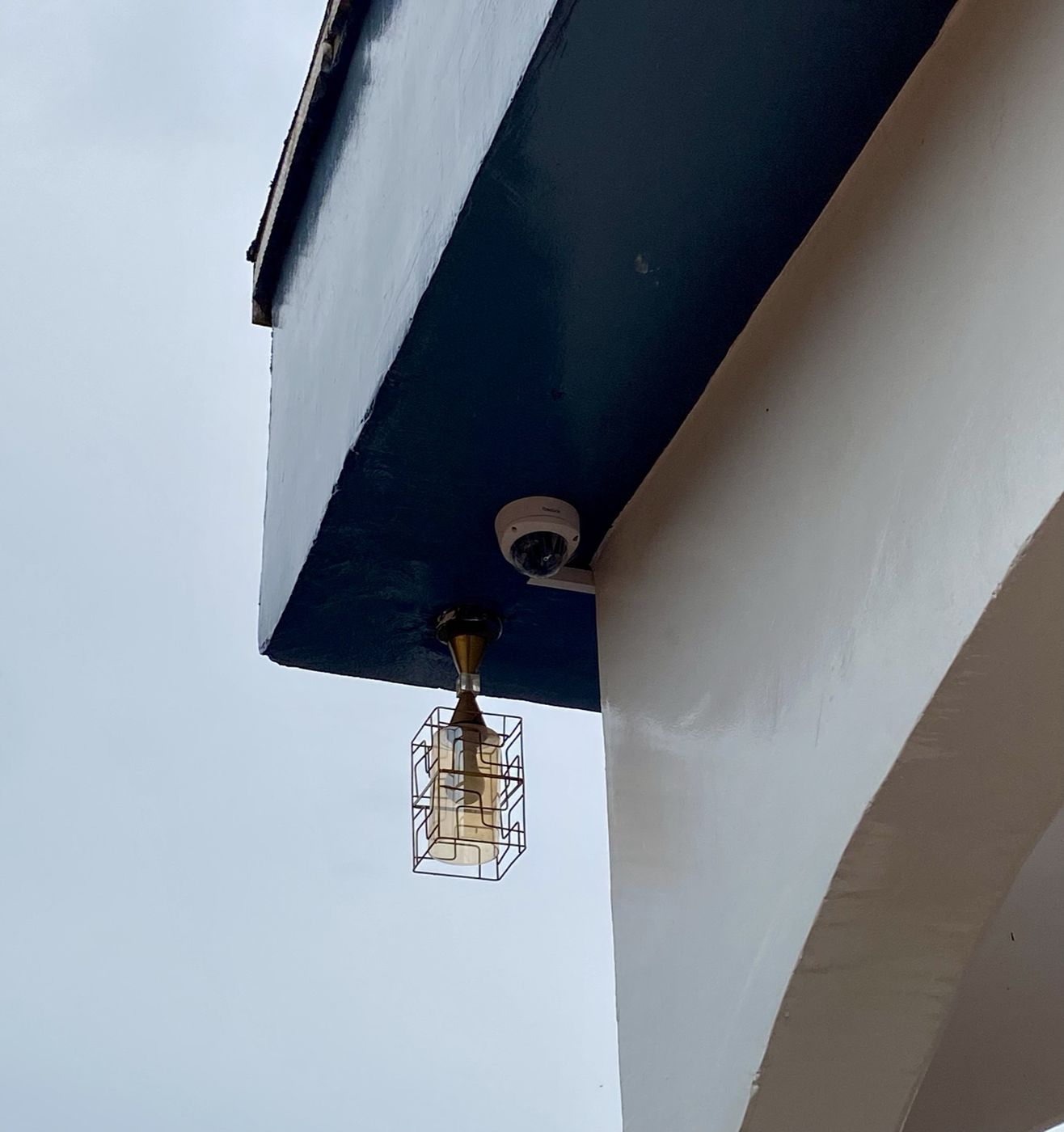 Caméra dôme installée sous un auvent, à proximité d'un point d'éclairage