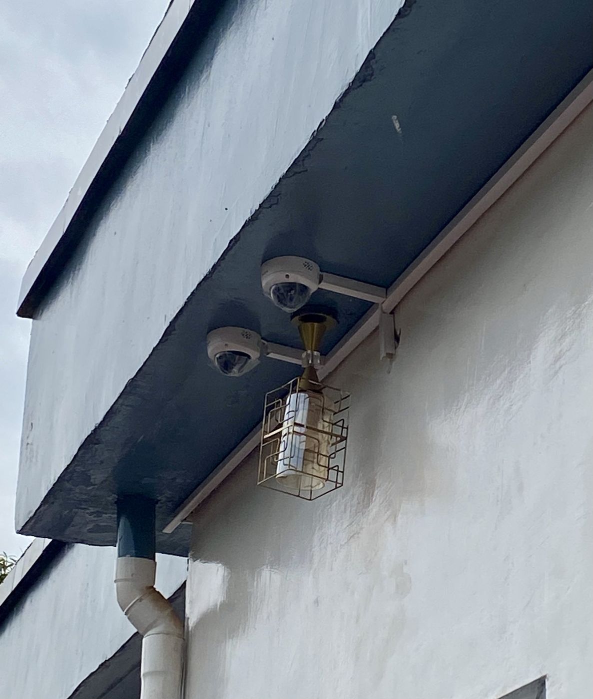 Deux caméras dômes fixées sous le débord de toiture, câblage en goulotte
